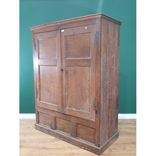 9 - An antique oak and elm Hall Cupboard, the moulded cornice above a pair of panelled doors, above thre... 