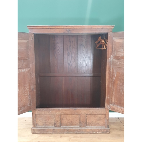 9 - An antique oak and elm Hall Cupboard, the moulded cornice above a pair of panelled doors, above thre... 