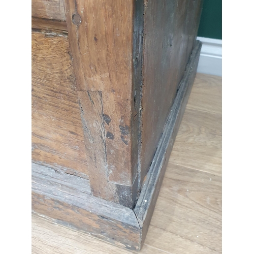 9 - An antique oak and elm Hall Cupboard, the moulded cornice above a pair of panelled doors, above thre... 