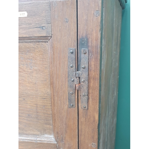 9 - An antique oak and elm Hall Cupboard, the moulded cornice above a pair of panelled doors, above thre... 