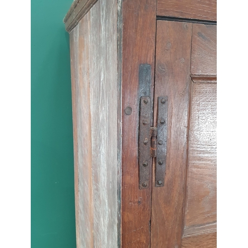 9 - An antique oak and elm Hall Cupboard, the moulded cornice above a pair of panelled doors, above thre... 