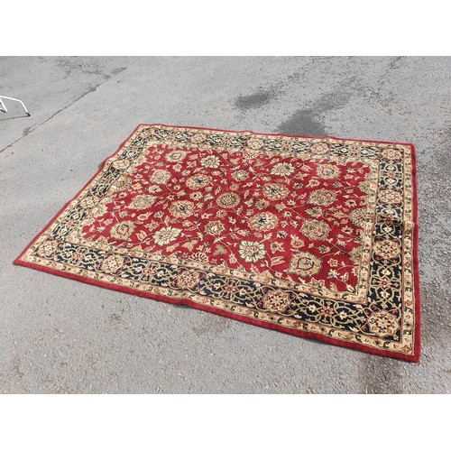 733 - An Indian woollen Carpet, with floral designs on a red ground, 10ft 9in x 7ft 11in