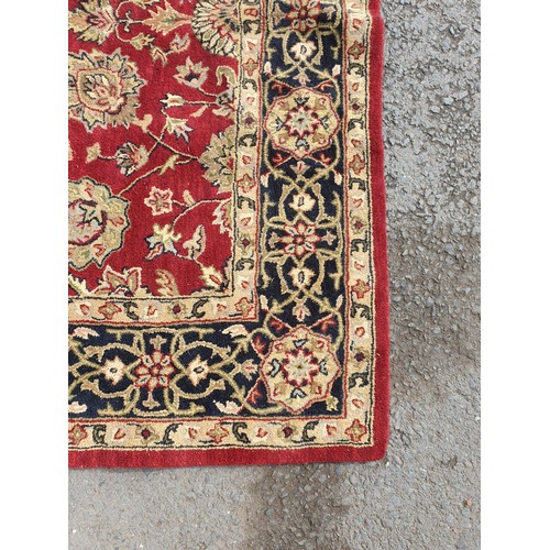 733 - An Indian woollen Carpet, with floral designs on a red ground, 10ft 9in x 7ft 11in