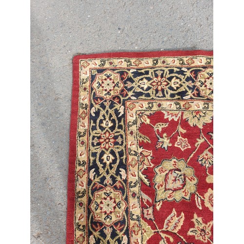 733 - An Indian woollen Carpet, with floral designs on a red ground, 10ft 9in x 7ft 11in