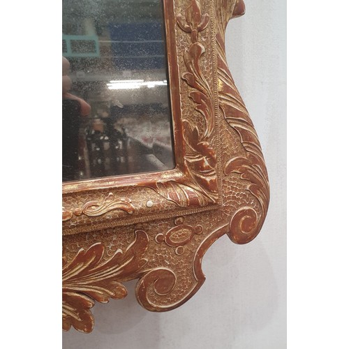 557 - A gilt framed Wall Mirror with elaborate scrolled surmount above the bevelled plate, 3ft 4in H (amen... 