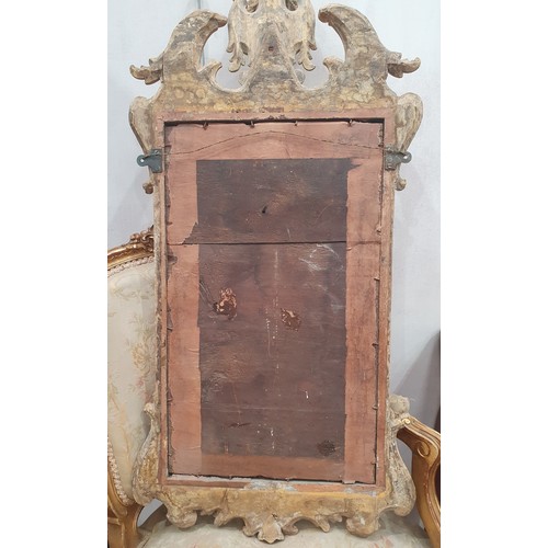 557 - A gilt framed Wall Mirror with elaborate scrolled surmount above the bevelled plate, 3ft 4in H (amen... 