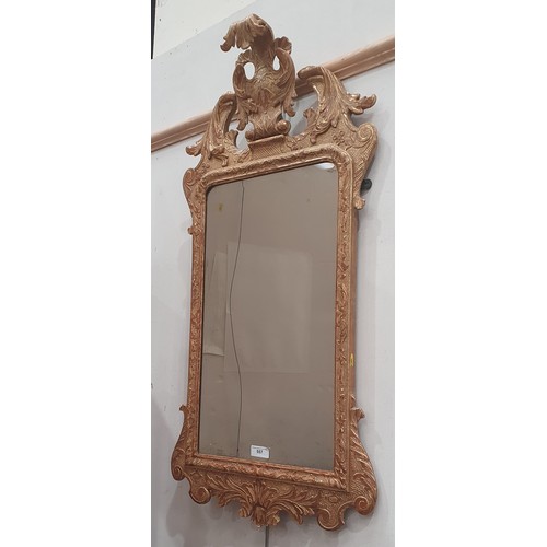 557 - A gilt framed Wall Mirror with elaborate scrolled surmount above the bevelled plate, 3ft 4in H (amen... 