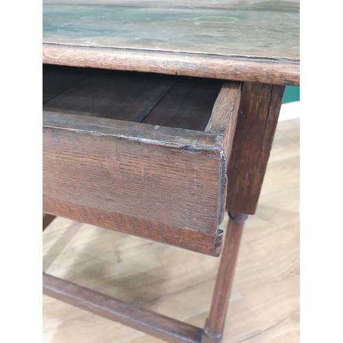 527 - An antique oak Side Table with single fitted drawer on turned supports and square stretchers and bun... 