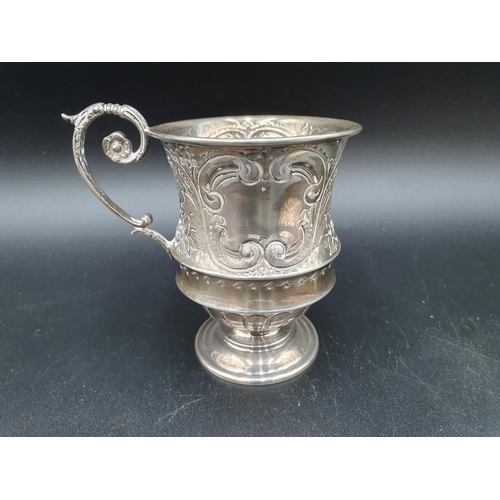 110 - A Victorian silver Christening Mug with floral and scroll embossing on pedestal base, Sheffield 1900... 