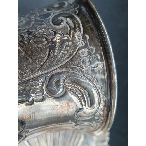 110 - A Victorian silver Christening Mug with floral and scroll embossing on pedestal base, Sheffield 1900... 