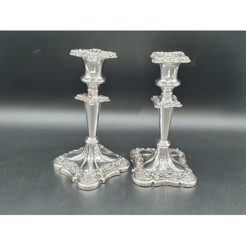 124 - A pair of Victorian plated Candlesticks with foliate friezes on shaped square bases, 8in