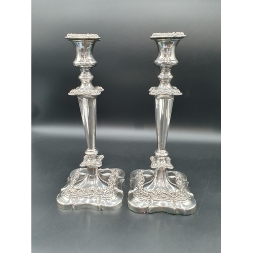 140 - A pair of plated Candlesticks with plain tapering columns, foliate bands on shaped square bases, 12i... 