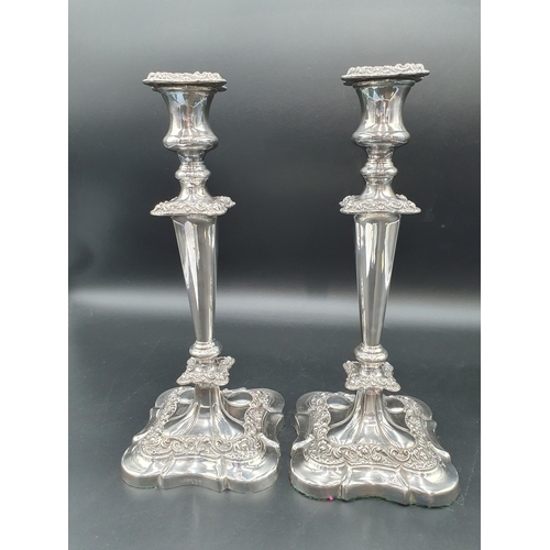 140 - A pair of plated Candlesticks with plain tapering columns, foliate bands on shaped square bases, 12i... 