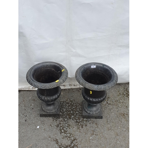 225 - A pair of black painted cast iron Garden Urns on pedestal bases, 17in H