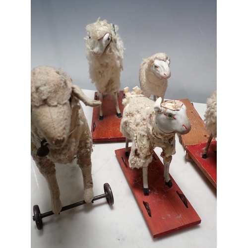 277 - Seven Vintage Putz style Sheep Models on wheels, A/F. (R7).