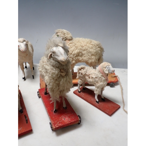 277 - Seven Vintage Putz style Sheep Models on wheels, A/F. (R7).