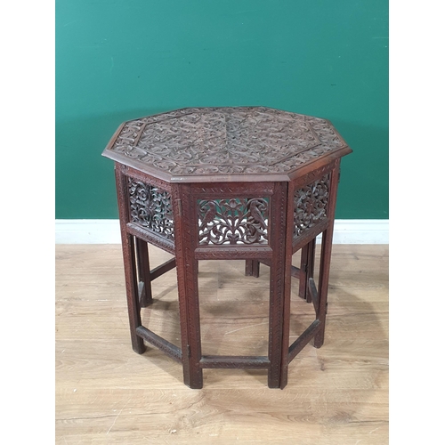 298 - An Eastern carved hardwood octagonal folding Occasional Table, the top with carved floral and leafag... 