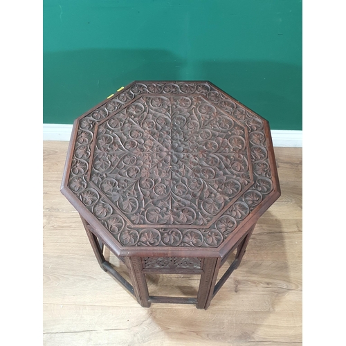 298 - An Eastern carved hardwood octagonal folding Occasional Table, the top with carved floral and leafag... 