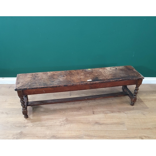 35 - An antique flame mahogany veneered and oak Window Bench on barley twist supports (veneer cracked A/F... 