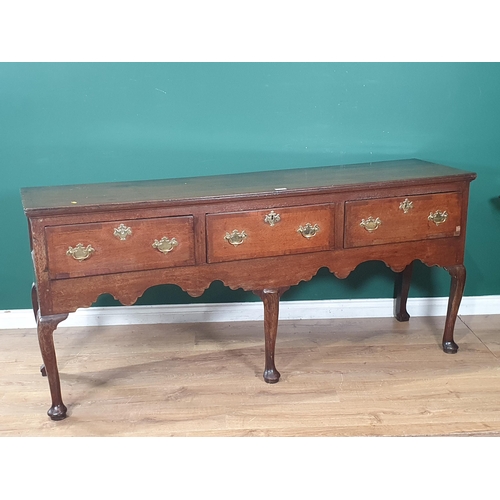 575 - An 18th Century oak Dresser Base fitted three drawers with shaped apron raised on three cabriole fro... 