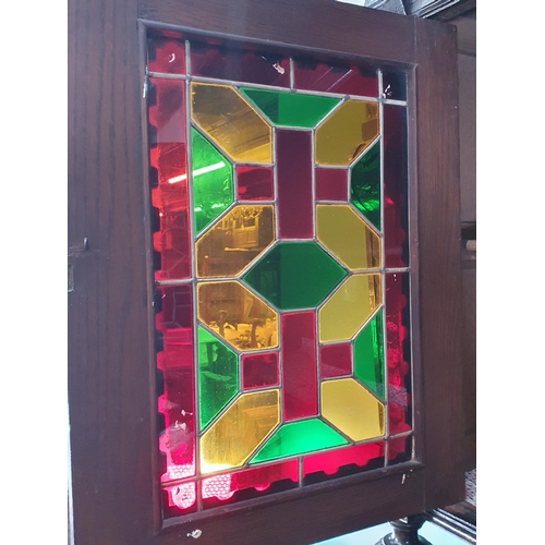 644 - A Victorian carved oak Cupboard with upper section fitted two lead glazed doors above base fitted pa... 