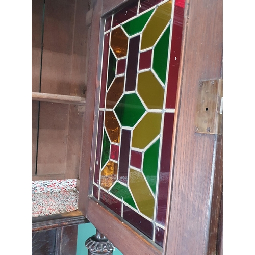 644 - A Victorian carved oak Cupboard with upper section fitted two lead glazed doors above base fitted pa... 