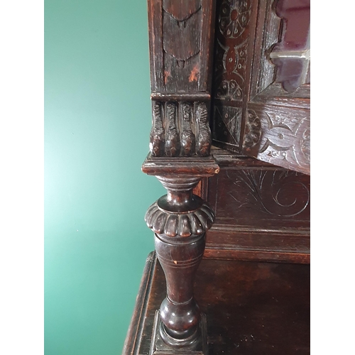 644 - A Victorian carved oak Cupboard with upper section fitted two lead glazed doors above base fitted pa... 