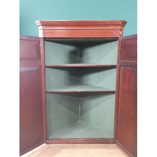 663 - An oak hanging Corner Cupboard the pair of panelled doors enclosing two fitted shelves, 3ft 6