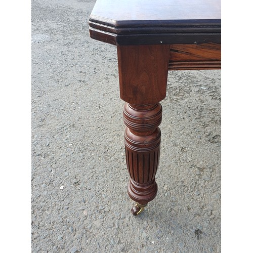 449 - A late 19th Century walnut extending Dining Table on turned supports and casters