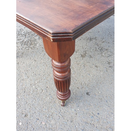 449 - A late 19th Century walnut extending Dining Table on turned supports and casters