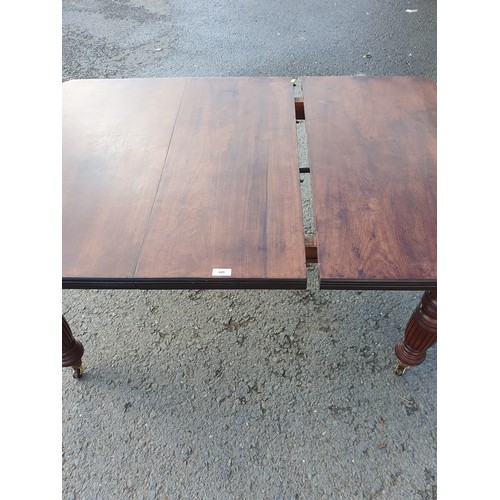 449 - A late 19th Century walnut extending Dining Table on turned supports and casters