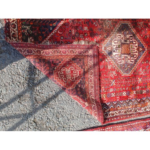 217 - Two Persian Rugs with lozenge designs on red grounds, 8ft 5in x 5ft 6in and 9ft 2in x 6ft 9in A/F