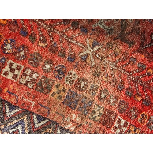 217 - Two Persian Rugs with lozenge designs on red grounds, 8ft 5in x 5ft 6in and 9ft 2in x 6ft 9in A/F