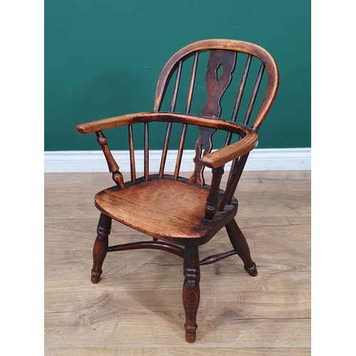 693 - A 19th Century child's ash back Windsor Elbow Chair with pierced splat back on baluster turned suppo... 