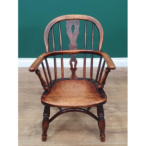 693 - A 19th Century child's ash back Windsor Elbow Chair with pierced splat back on baluster turned suppo... 