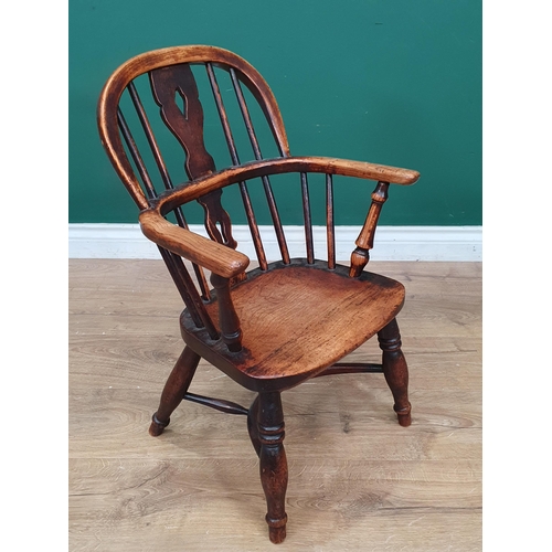 693 - A 19th Century child's ash back Windsor Elbow Chair with pierced splat back on baluster turned suppo... 