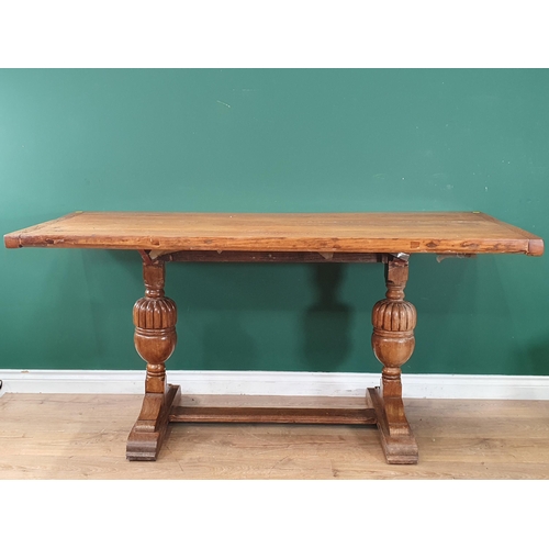 697 - An oak Refectory Table the rectangular plank top, raised on pair of turned column supports united by... 