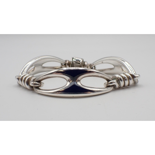 179 - Mappin & Webb: A silver and enamel Bracelet designed as three openwork oval sections decorated blue ... 