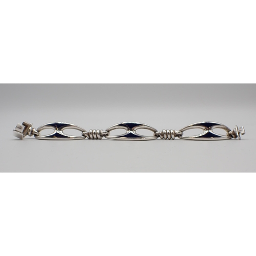 179 - Mappin & Webb: A silver and enamel Bracelet designed as three openwork oval sections decorated blue ... 