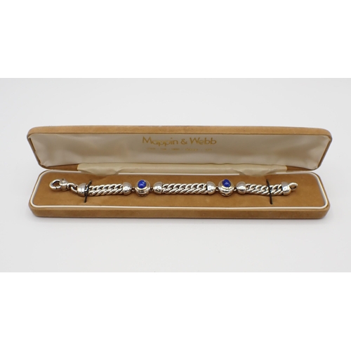 180 - Mappin & Webb: A silver, gold and Lapis Lazuli Bracelet the flattened curb linking interspaced with ... 