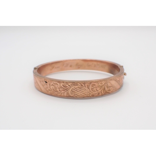 181 - A 9ct gold hinged Bangle with scroll engraving to front and presentation inscription to inside, appr... 