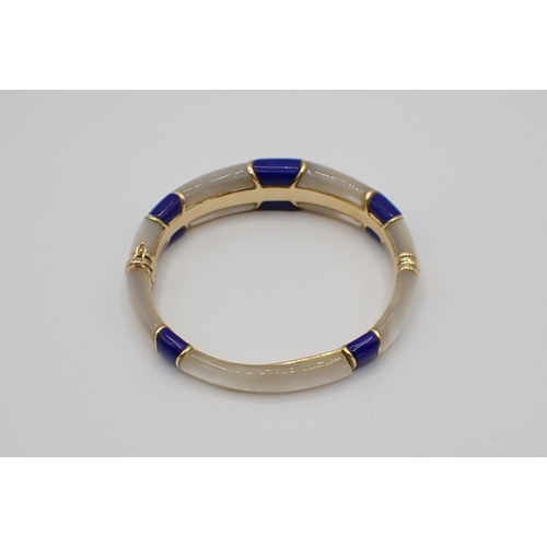 189 - A Mother of Pearl and Lapis Lazuli hinged Bangle set alternating panels, marked 14KP