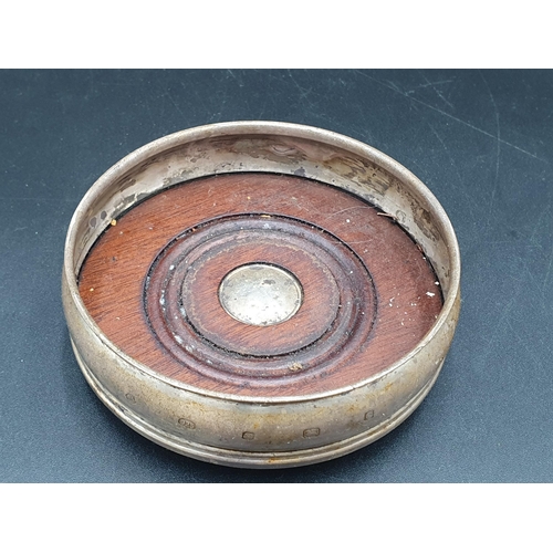 104 - A modern silver circular Coaster with turned wooden base, Sheffield 2002