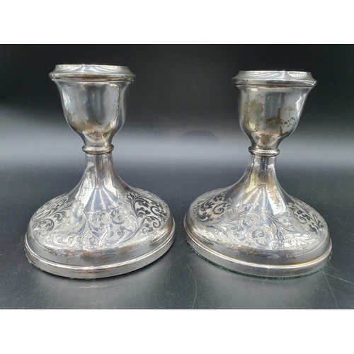 143 - A pair of Elizabeth II silver Candlesticks with leafage scroll engraving on circular bases, Birmingh... 