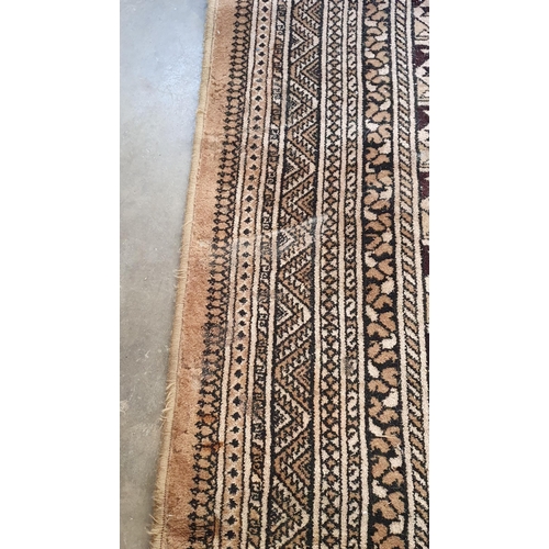 291 - A large bordered carpet, of multi-bordered design with rows of medallions on a beige ground, 12ft x ... 