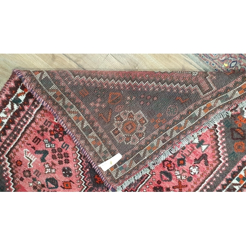 292 - A small Persian Rug, with stylised floral motifs on a red ground, 4ft 10in x 3ft 5in (R6)