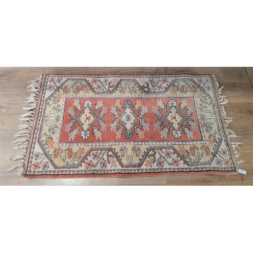 297 - A small Turkish wool Rug with three medallions on a red ground, 4ft 6in x 2ft 8in (R4/R5)