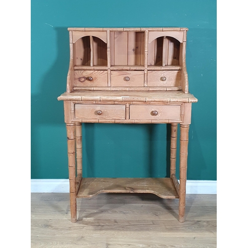 33 - A pitch pine simulated bamboo Desk, the raised back fitted drawers and pigeonholes with two frieze d... 