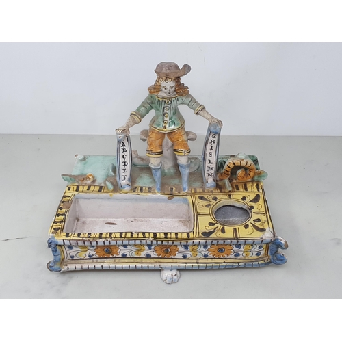 43 - An antique delft Desk Stand decorated with seated figure in period costume on paw feet (four missing... 