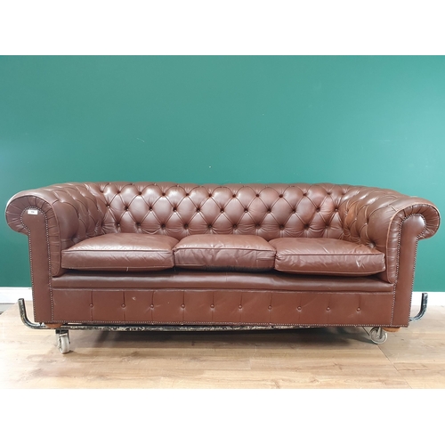 554 - A leather style button upholstered Chesterfield Settee, on turned supports, 7ft W approximately